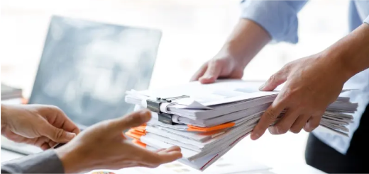 a person handing paperwork to another person